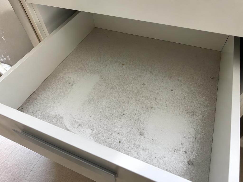 Fine renovation dust settled inside an open kitchen drawer