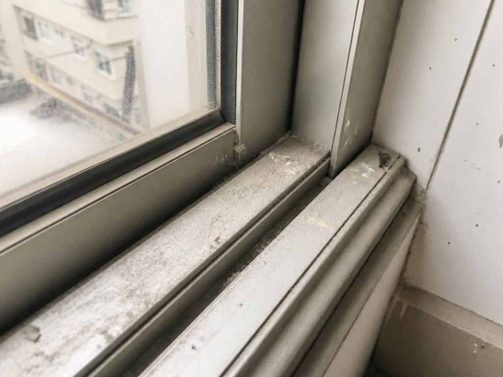 Dusty aluminium window track and frame with construction residue